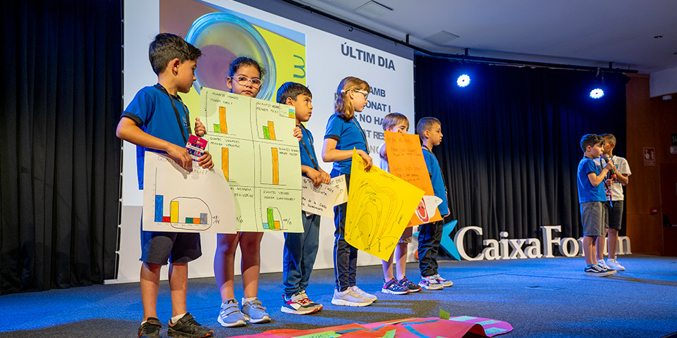 Grup de nens i nenes presentant el seu projecte al congrés científic de PTC a Tarragona